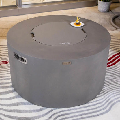 Close-up lifestyle view of the Elementi Art of Living Pacaya Light Grey round fire pit table with the matching burner cover in place. Positioned on a patterned outdoor rug and styled with a decorative dessert plate, the image highlights the smooth GFRC concrete finish, circular tabletop design, and versatility as a functional outdoor coffee table.