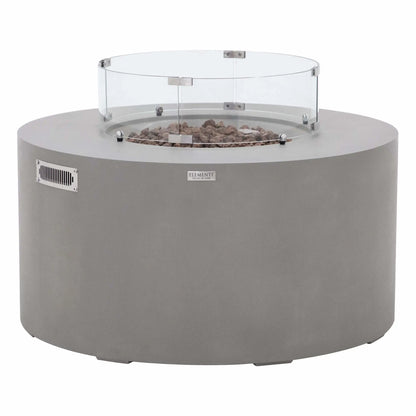 Front product view of the Elementi Art of Living Pacaya Light Grey GFRC concrete fire pit table equipped with a circular tempered glass wind guard. Displayed on a white background, the image highlights the round fire bowl, lava rock media, ventilation panel, and protective glass enclosure designed to improve flame stability while maintaining a clean modern outdoor living appearance.