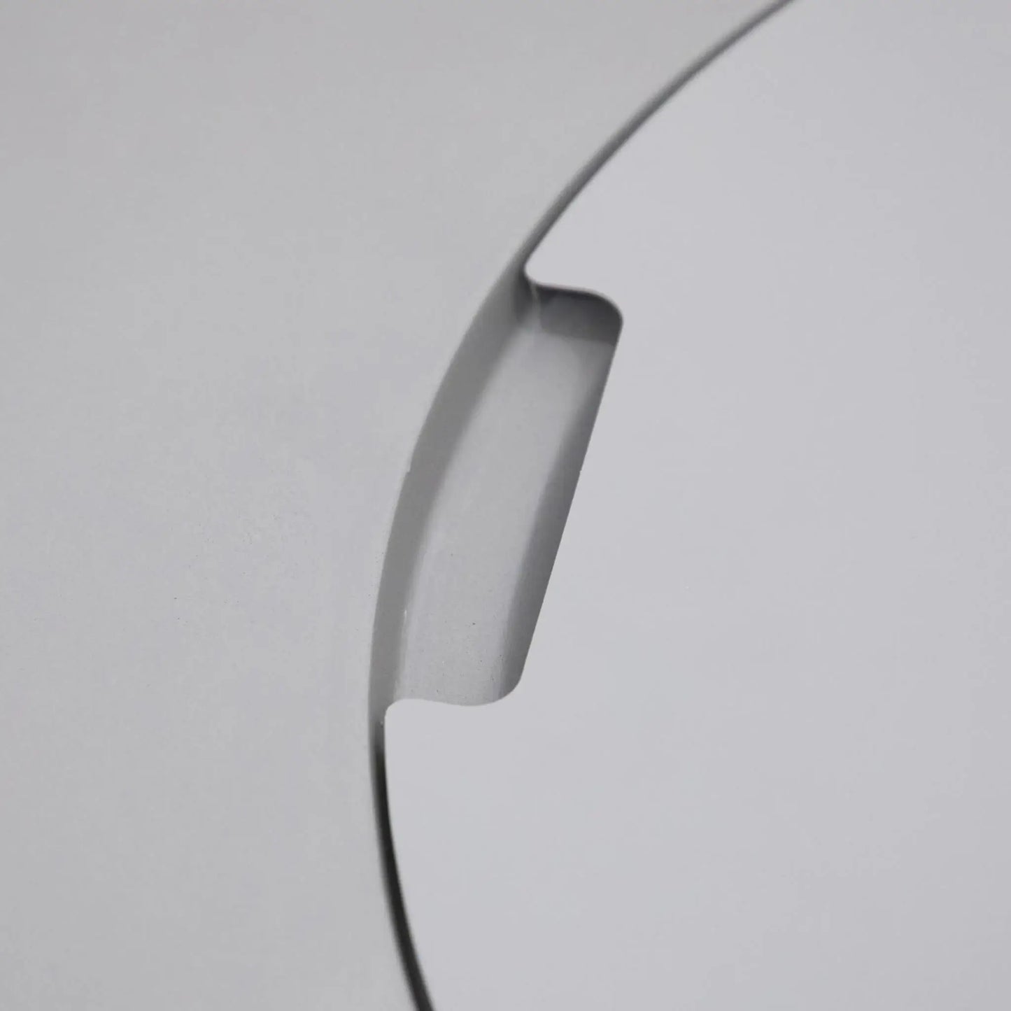 Close-up detail of the integrated burner lid handle cutout on the Elementi Art of Living Pacaya Light Grey round GFRC concrete fire pit table. This image highlights the recessed finger grip designed for easy removal of the circular burner cover, showcasing the smooth concrete finish, precision craftsmanship, and concealed fire pit functionality of the Pacaya hidden propane fire pit table.