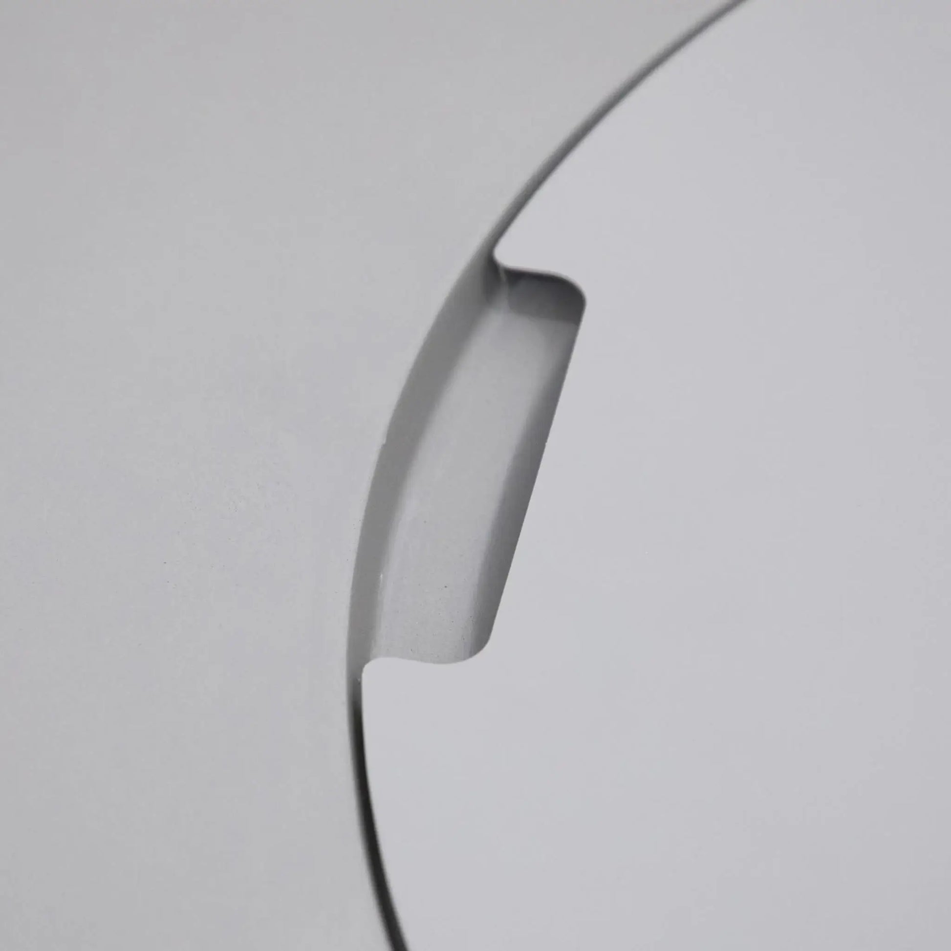 Close-up detail of the integrated burner lid handle cutout on the Elementi Art of Living Pacaya Light Grey round GFRC concrete fire pit table. This image highlights the recessed finger grip designed for easy removal of the circular burner cover, showcasing the smooth concrete finish, precision craftsmanship, and concealed fire pit functionality of the Pacaya hidden propane fire pit table.