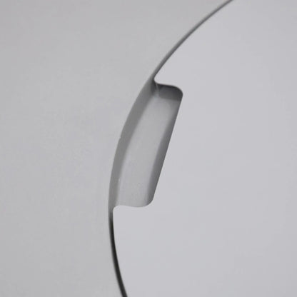 Close-up detail of the integrated burner lid handle cutout on the Elementi Art of Living Pacaya Light Grey round GFRC concrete fire pit table. This image highlights the recessed finger grip designed for easy removal of the circular burner cover, showcasing the smooth concrete finish, precision craftsmanship, and concealed fire pit functionality of the Pacaya hidden propane fire pit table.