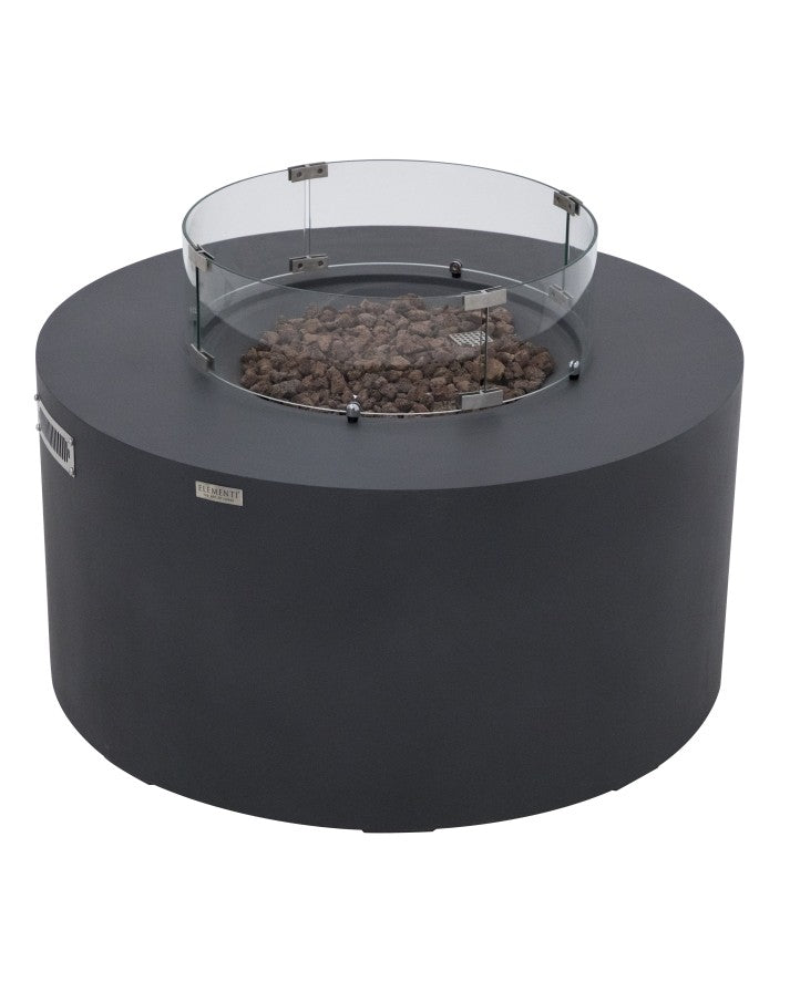 Elementi Pacaya Round Fire Pit Table in dark grey GFRC concrete, featuring a tempered glass wind guard and natural lava rock media. This modern fire pit boasts a hidden propane tank compartment for a sleek aesthetic, while the wind guard enhances flame stability and safety. A perfect blend of durability and contemporary design, making it an ideal outdoor focal point for stylish gatherings.