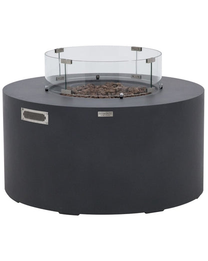 Elementi Pacaya Round Fire Pit Table in dark grey GFRC concrete, featuring a sleek glass wind guard and natural lava rock media. Designed with a hidden propane tank for a seamless look, this modern fire pit combines durability and elegance. The glass wind guard enhances flame stability while adding a contemporary touch, making it an ideal outdoor centerpiece for stylish gatherings.