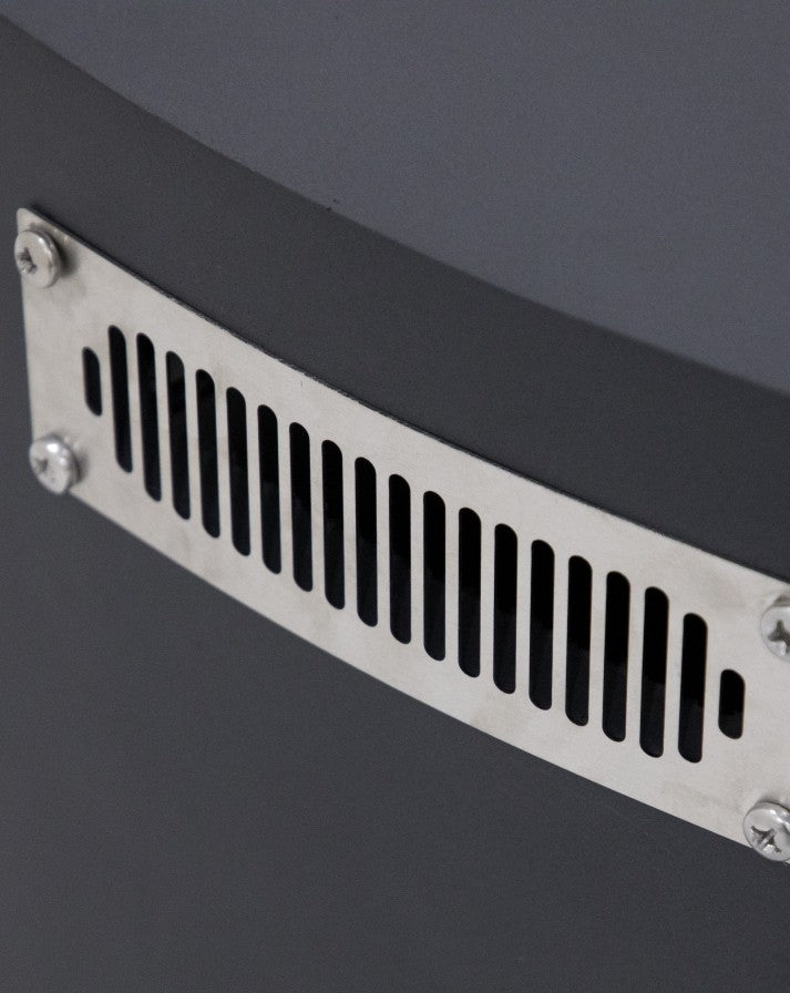 Close-up of the Elementi Pacaya Round Fire Pit Table’s stainless steel ventilation panel. Strategically designed for safety and airflow, this sleek vent ensures proper propane gas circulation while seamlessly integrating into the fire pit’s dark grey GFRC concrete body. A perfect blend of functionality and modern outdoor design.