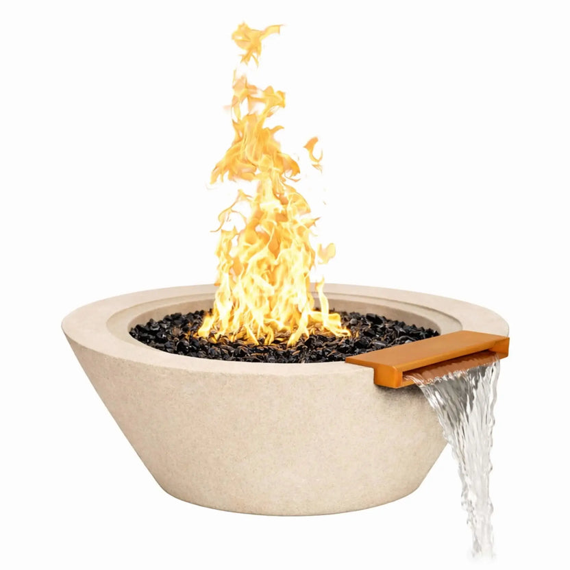 White round cone-style fire and water bowl with a wide open basin, black fire glass, active flame, and water spilling gracefully from a front-mounted bronze scupper over the bowl’s edge.