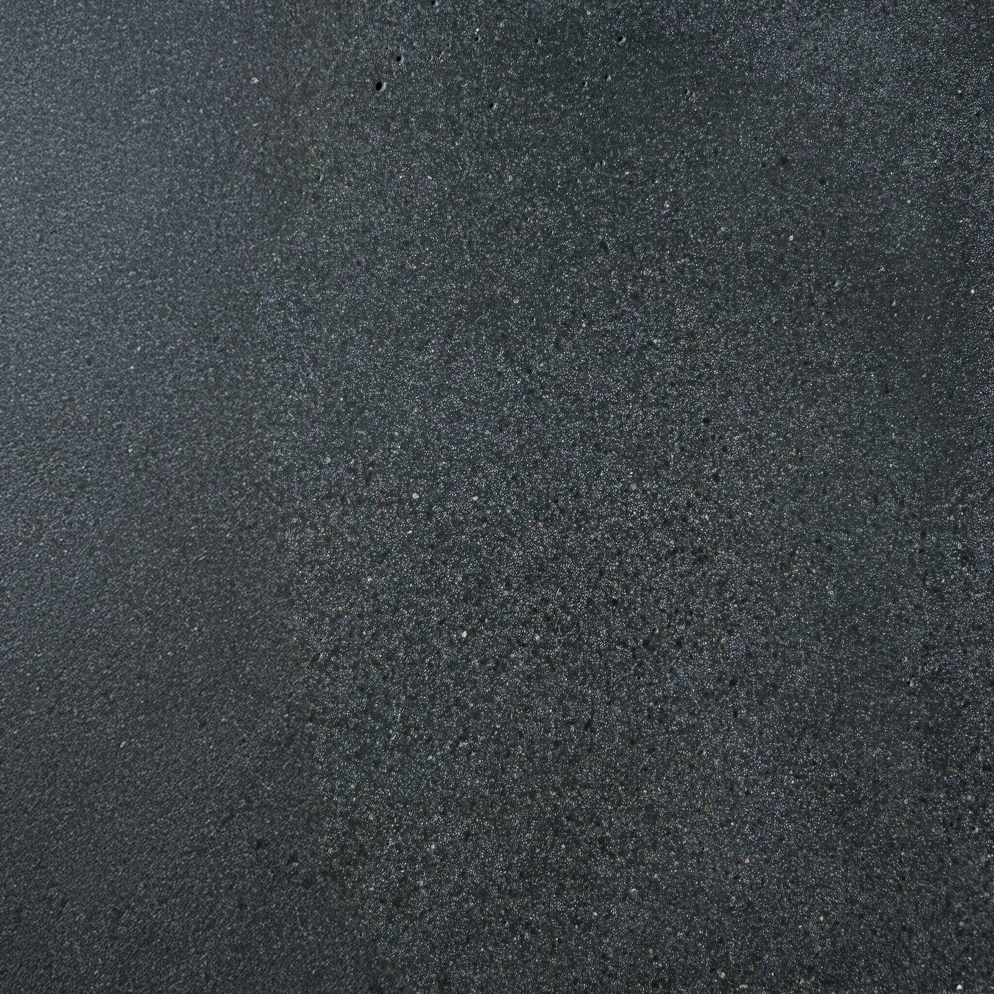 Close-up texture sample of Flame Havens Concrete GFRC Glass Fiber Reinforced Concrete Swatch Black V4 finish. The image showcases a dark charcoal black concrete surface with subtle tonal variation, fine aggregate detailing, and a lightly textured matte appearance designed for modern outdoor fire pit tables, concrete fire features, and contemporary patio furniture applications.