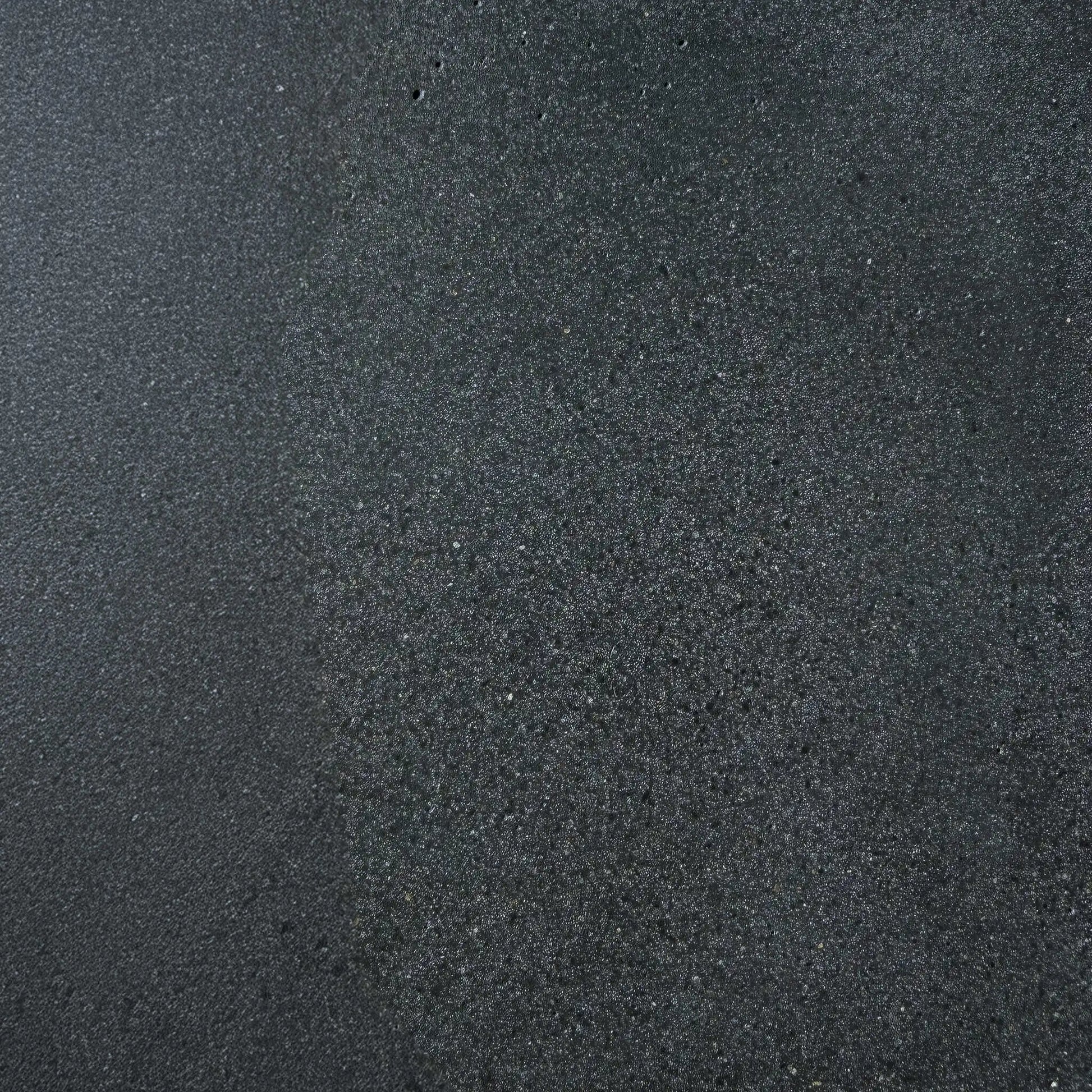 Close-up texture sample of Flame Havens Concrete GFRC Glass Fiber Reinforced Concrete Swatch Black V4 finish. The image showcases a dark charcoal black concrete surface with subtle tonal variation, fine aggregate detailing, and a lightly textured matte appearance designed for modern outdoor fire pit tables, concrete fire features, and contemporary patio furniture applications.