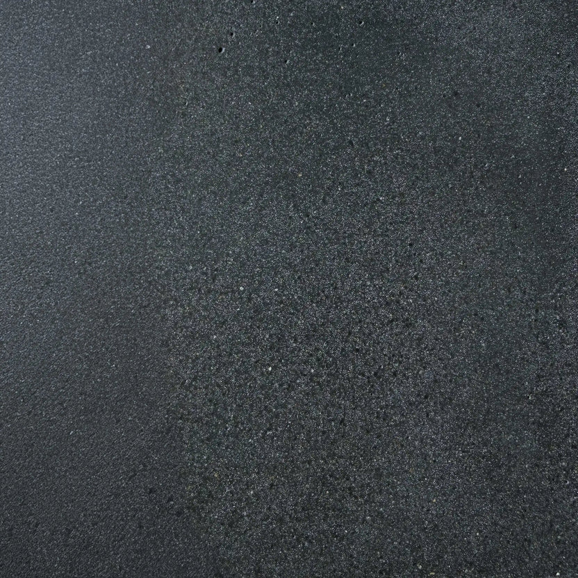 Close-up texture sample of Flame Havens Concrete GFRC Glass Fiber Reinforced Concrete Swatch Black V4 finish. The image showcases a dark charcoal black concrete surface with subtle tonal variation, fine aggregate detailing, and a lightly textured matte appearance designed for modern outdoor fire pit tables, concrete fire features, and contemporary patio furniture applications.