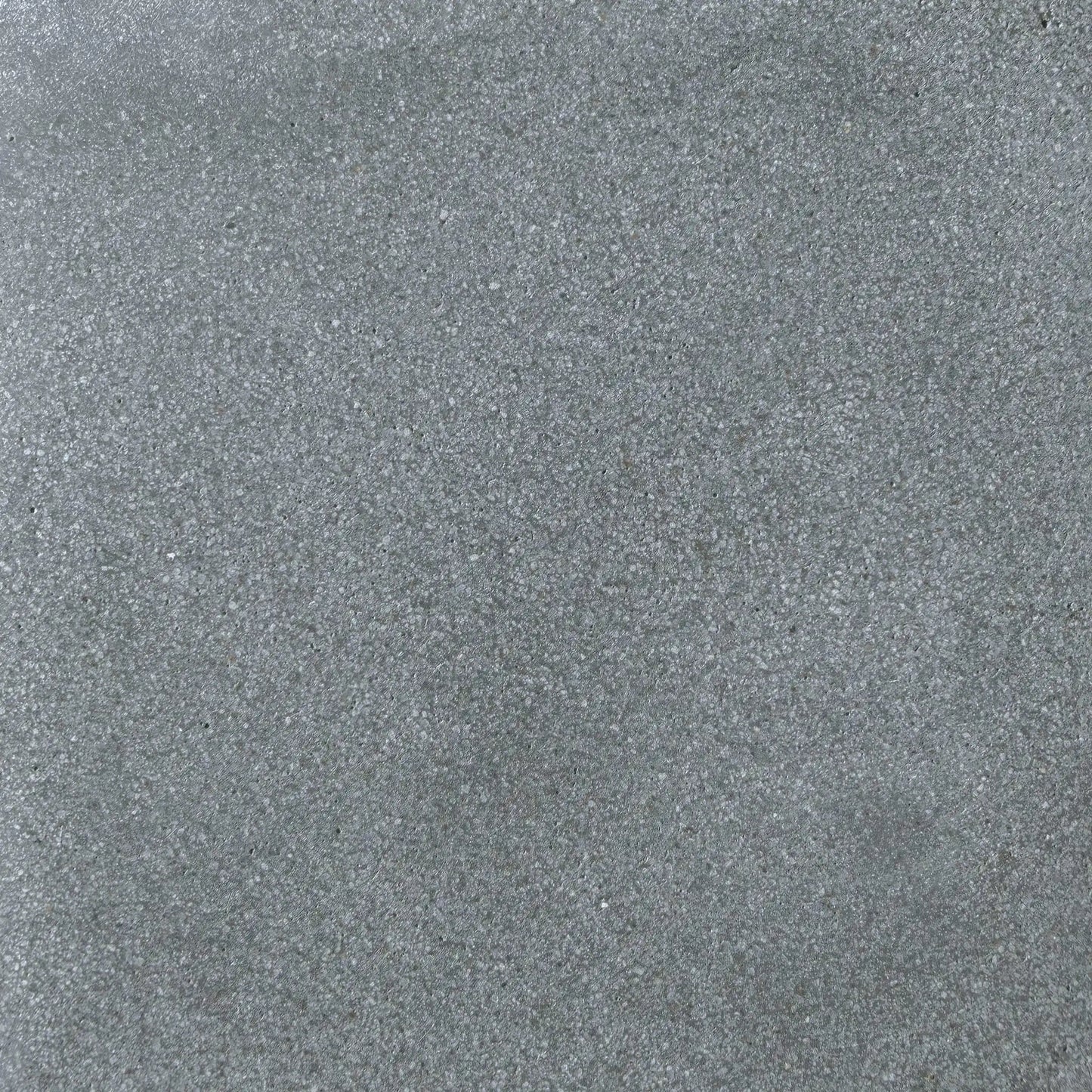Detailed surface texture of Flame Havens Concrete GFRC Glass Fiber Reinforced Concrete Swatch Gray V4 finish. This close-up image highlights the smooth gray concrete coloration with fine speckled aggregate, soft tonal movement, and durable matte texture commonly used on GFRC concrete fire pits, outdoor fire tables, and modern patio heating products.
