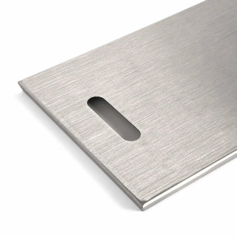 Close-up of the left handle on the Flame Havens Refuge Series 33 x 11-inch rectangular stainless steel burner cover. The image highlights the smooth, rounded rectangular hand opening, brushed stainless steel surface, neatly finished corner, and raised edge against a clean white background.