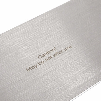 Detailed close-up of the Flame Havens Refuge Series rectangular 45 x 11-inch stainless steel burner cover. The image focuses on the visible brushed grain across the metal surface and the clearly printed “Caution! May be hot after use” safety warning near the center.
