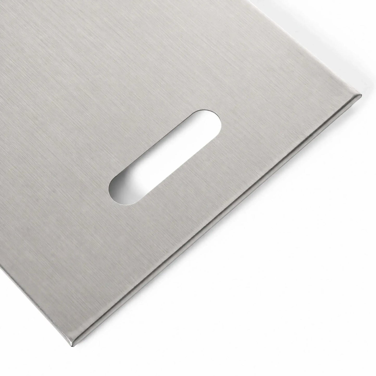 Close-up of the right handle opening on the Flame Havens Refuge Series 45 x 11-inch stainless steel rectangular burner cover. The image shows the smooth, elongated handhold, brushed stainless steel grain, squared corner, and neatly folded outer edge on a white background.
