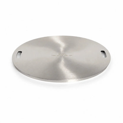 Main view of the Flame Havens Refuge Series 24-inch round stainless steel burner cover. Shown at a low angle on a white background, the circular accessory features a reflective brushed finish, two integrated handle openings, a slim raised edge, and the engraved message, “Caution! May be hot after use.”