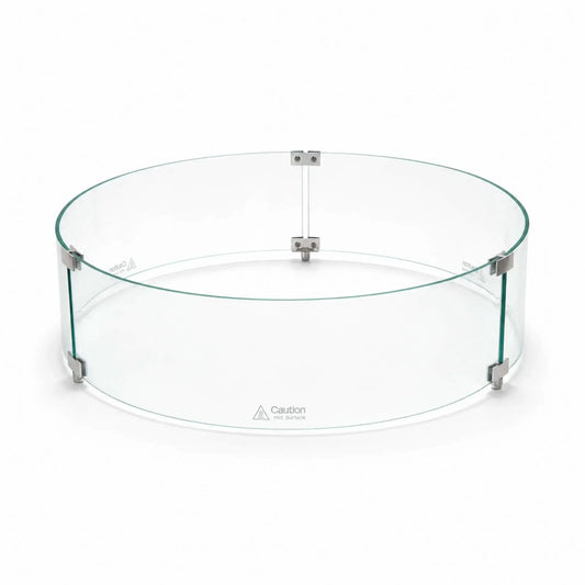 Angled main view of the assembled Flame Havens Refuge Series tempered glass wind guard shield, measuring 28 inches in diameter by 7 inches tall. Three curved clear glass panels form a complete circle, joined by silver clamps and raised support feet, with “Caution Hot Surface” warnings near the bottom.