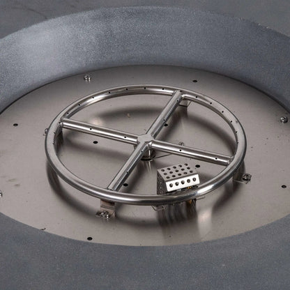 Close-up view inside the Flame Havens Refuge Series 36-inch Round Natural Gas Gray GFRC Concrete Fire Pit showing the stainless steel circular burner ring, CSA-certified ignition assembly, and precision-engineered burner components before the fire glass is installed. The image highlights the durable stainless steel construction and professional burner layout.