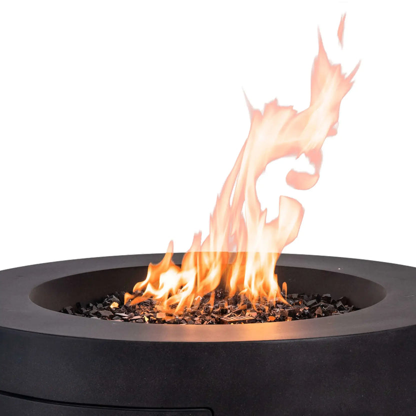 Flame Havens Refuge Series 36-inch Round Propane Gas GFRC Concrete Fire Pit in Black operating with tall natural flames rising above premium Black Reflective Fire Glass. This image highlights the Graphite Black concrete finish, stainless steel burner system, and realistic fire display, showcasing a luxury outdoor fire pit designed for modern patios, pool decks, and backyard entertaining.