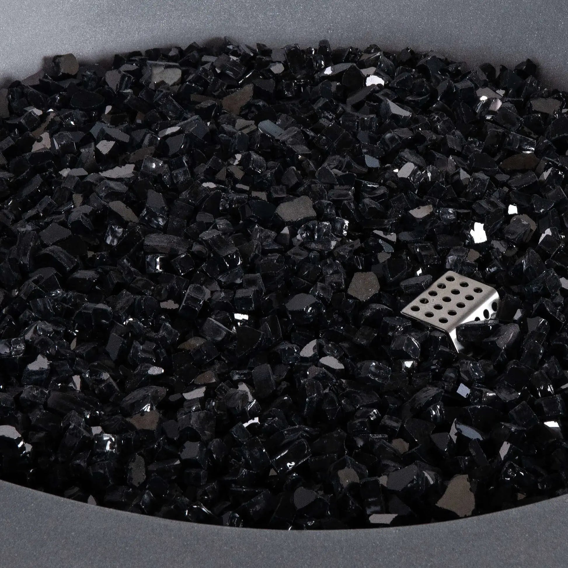 Detailed close-up of the Flame Havens Refuge Series 36-inch Round Propane Gas GFRC Concrete Fire Pit featuring premium Black Reflective Fire Glass. The image highlights the reflective tempered glass media, concealed stainless steel ignitor, and smooth Natural Gray GFRC concrete finish, emphasizing the premium materials used throughout the Refuge Series fire pit.