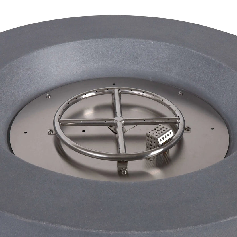 Close-up of the Flame Havens Refuge Series 36-inch Round Propane Gas GFRC Concrete Fire Pit burner assembly showing the stainless steel circular burner ring, CSA-certified ignition system, and stainless burner pan before decorative Black Reflective Fire Glass is installed. The image highlights the quality construction and precision-engineered burner components.