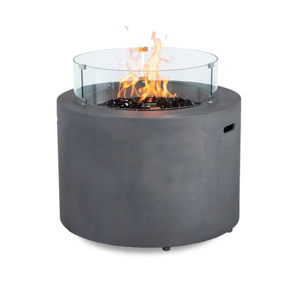 Front view of the Flame Havens Refuge Series 36-inch Round Propane Gas GFRC Concrete Fire Pit in Natural Gray operating with tall propane flames above premium Black Reflective Fire Glass. The optional tempered glass wind guard surrounds the burner, providing added flame protection while maintaining a clear view of the fire. The durable GFRC concrete construction creates a modern centerpiece for luxury outdoor living spaces.