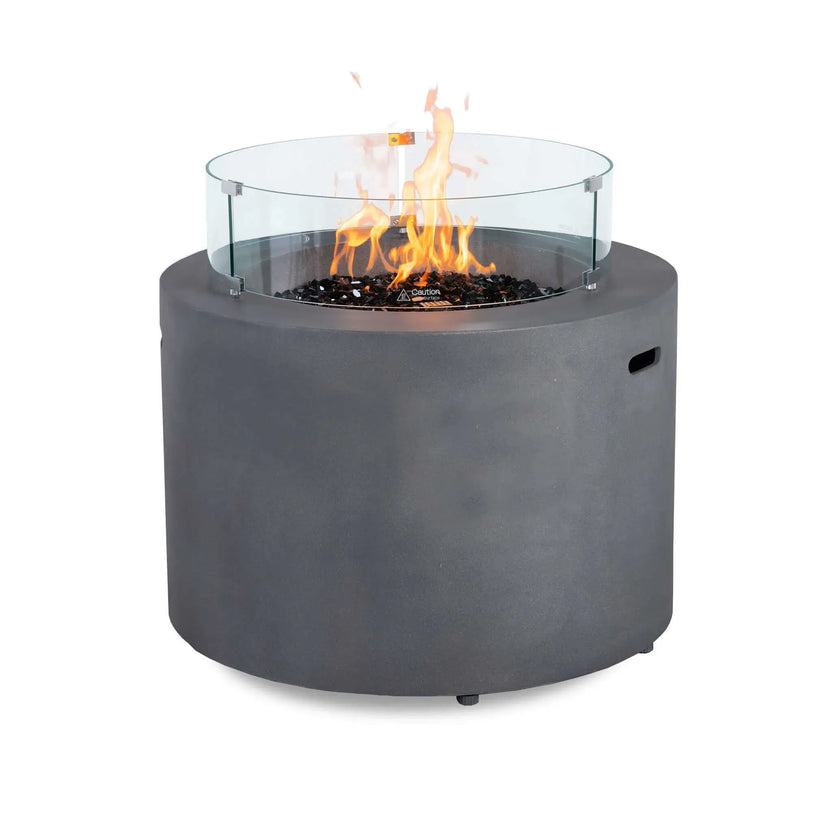 Front view of the Flame Havens Refuge Series 36-inch Round Propane Gas GFRC Concrete Fire Pit in Natural Gray operating with tall propane flames above premium Black Reflective Fire Glass. The optional tempered glass wind guard surrounds the burner, providing added flame protection while maintaining a clear view of the fire. The durable GFRC concrete construction creates a modern centerpiece for luxury outdoor living spaces.