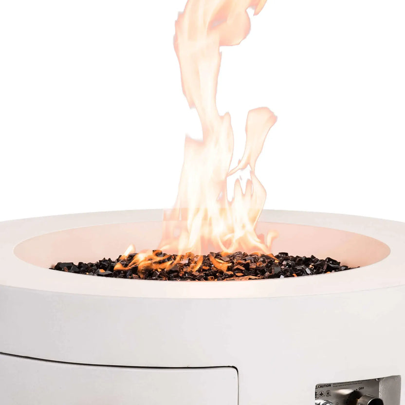 Close-up of the Flame Havens Refuge Series 36-inch Round Propane Gas GFRC Concrete Fire Pit in Ivory White with vibrant flames rising above premium Black Reflective Fire Glass. The image showcases the stainless steel burner system, CSA ignition components, and modern round fire pit design, creating a striking focal point for luxury outdoor entertaining spaces.