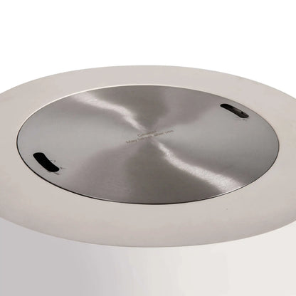 Top view of the Flame Havens Refuge Series 36-inch Round Propane Gas GFRC Concrete Fire Pit in Ivory White with the optional Stainless Steel Burner Cover installed. The brushed stainless steel cover fits flush inside the burner opening, creating a smooth tabletop surface while protecting the burner when the fire pit is not in operation.