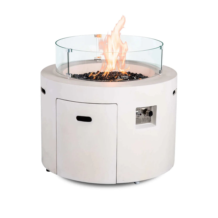 Rear product view of the Flame Havens Refuge Series 36-inch Round Propane Gas GFRC Concrete Fire Pit in Ivory White operating with premium Black Reflective Fire Glass and the optional tempered glass wind guard installed. The clear glass wind guard helps shield the flames while preserving unobstructed views and enhancing outdoor fire pit safety.