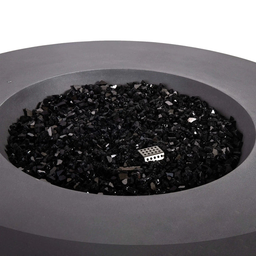 Top-down view of the Flame Havens Refuge Series 43-inch Round Natural Gas Gray GFRC Concrete Fire Pit filled with reflective tempered black fire glass. The image showcases the evenly distributed fire media, concealed stainless steel burner, and modern recessed burn area designed to create a clean, luxurious appearance before ignition.