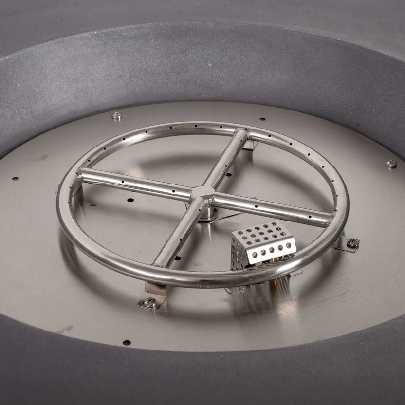 Detailed view of the stainless steel burner assembly and CSA-certified ignition system inside the Flame Havens Refuge Series 43-inch Round Natural Gas Gray GFRC Concrete Fire Pit. The circular burner ring, ignition module, and stainless steel burner pan are displayed before fire glass installation, highlighting the fire pit's premium engineering and durable construction.