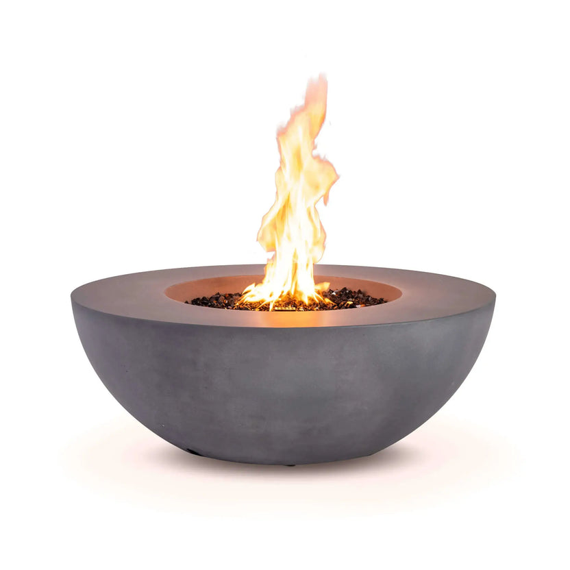 Front view of the Flame Havens Refuge Series 43-inch Round Natural Gas Gray GFRC Concrete Fire Pit burning with a vibrant natural gas flame rising from reflective tempered black fire glass. The clean exterior design conceals the controls, emphasizing the contemporary bowl profile and beautiful flame presentation.