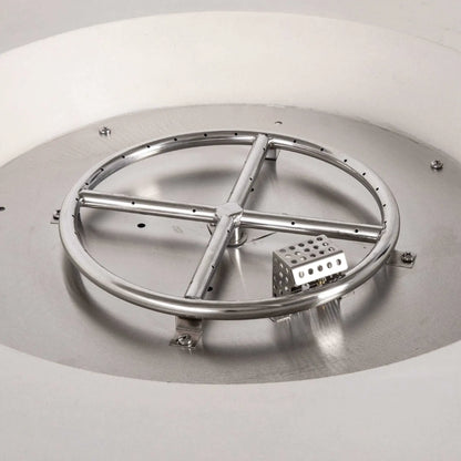 Close-up of the Flame Havens Refuge Series 43-inch Round Natural Gas White GFRC Concrete Fire Pit showing the stainless steel burner ring, CSA-certified ignition system, and ignition hood installed inside the stainless burner pan. This detailed view highlights the premium internal components before black fire glass is added.