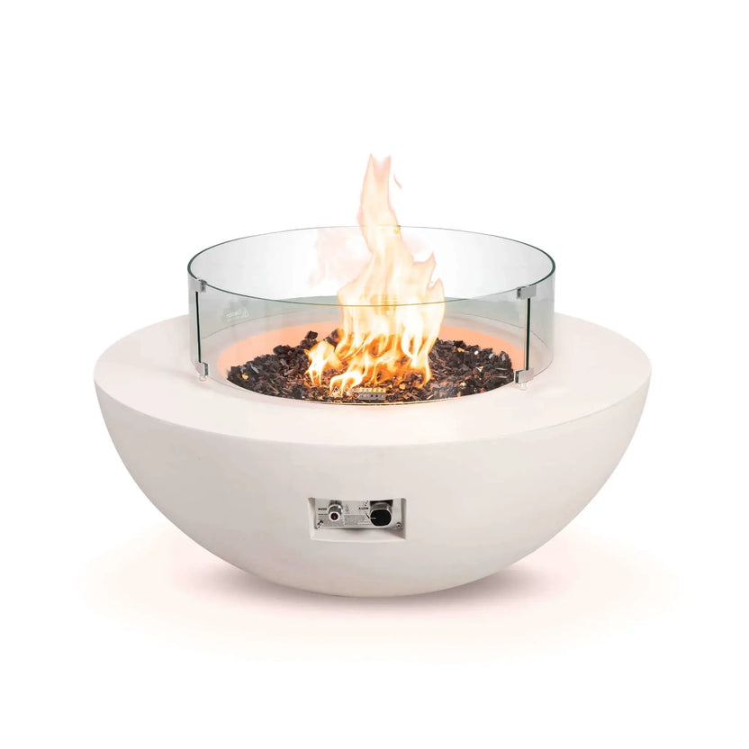 Front studio image of the Flame Havens Refuge Series 43-inch Round Natural Gas White GFRC Concrete Fire Pit equipped with a tempered glass wind guard. Reflective tempered black fire glass surrounds the natural gas flames while the clear circular wind guard helps protect and stabilize the flame without obstructing the view.