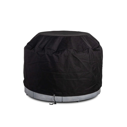 The Flame Havens Refuge Series 43-inch Round Propane Gas GFRC Concrete Fire Pit protected by its black canvas fabric cover while installed over the optional tempered glass wind guard. This fitted outdoor cover accommodates the wind guard, providing durable weather protection without removing the accessory, making seasonal storage quick and convenient.