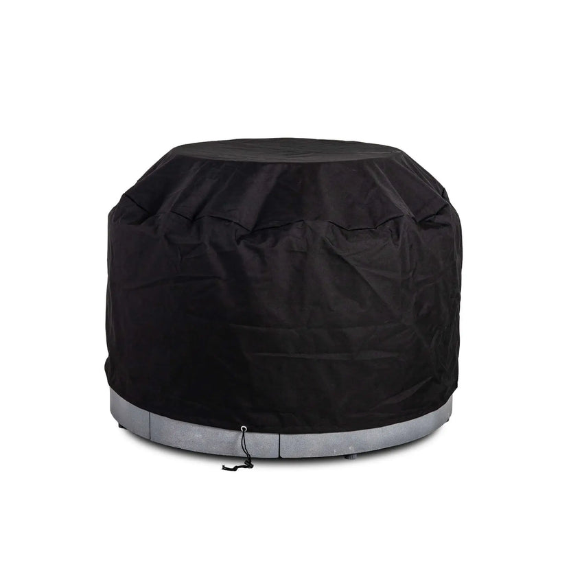 The Flame Havens Refuge Series 43-inch Round Propane Gas GFRC Concrete Fire Pit protected by its black canvas fabric cover while installed over the optional tempered glass wind guard. This fitted outdoor cover accommodates the wind guard, providing durable weather protection without removing the accessory, making seasonal storage quick and convenient.