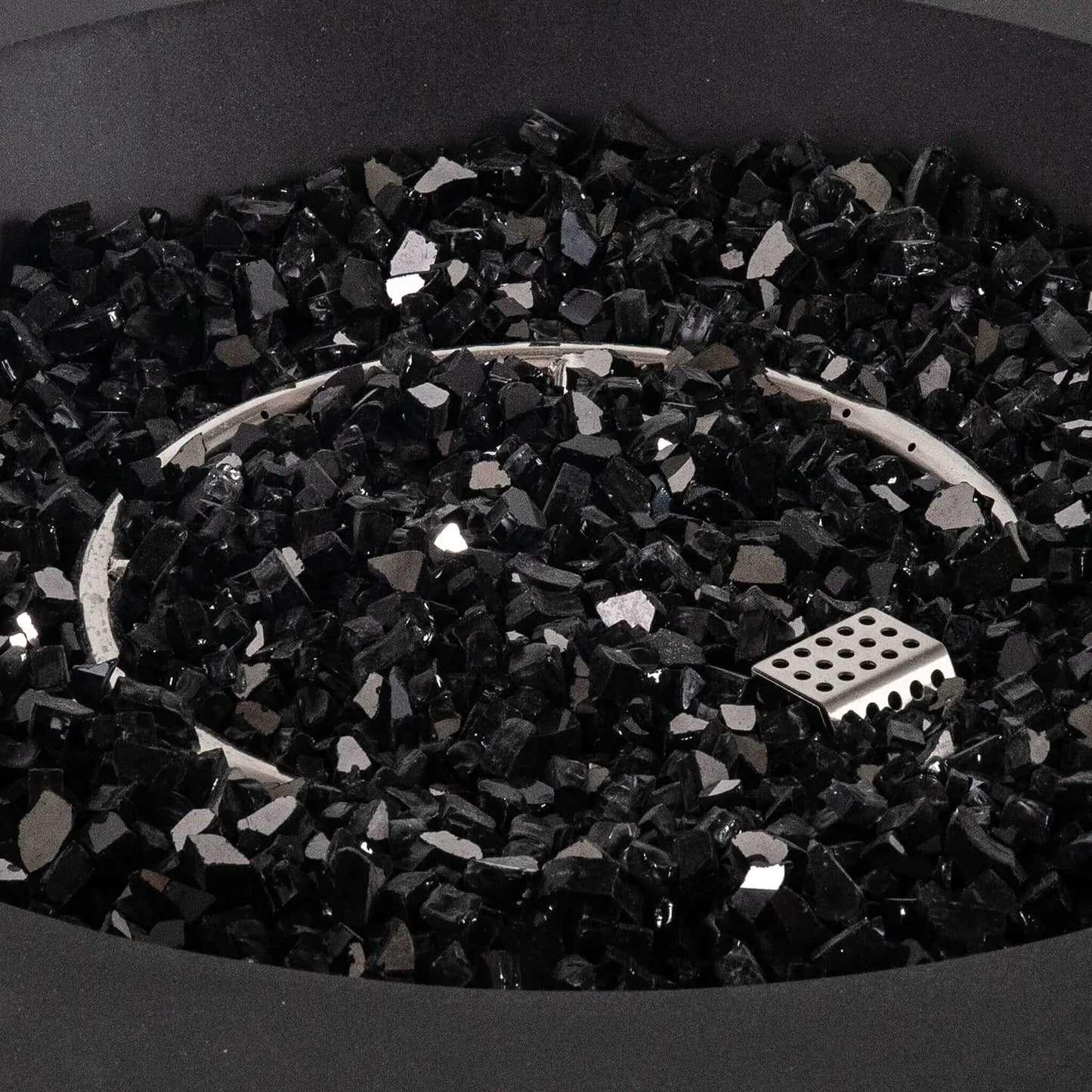Detailed close-up of the Flame Havens Refuge Series 43-inch Round Propane Gas GFRC Concrete Fire Pit featuring premium 1/2-inch black reflective fire glass surrounding the stainless steel circular burner and CSA ignition system. The image emphasizes the luxurious reflective media, precision burner layout, and smooth black concrete finish.