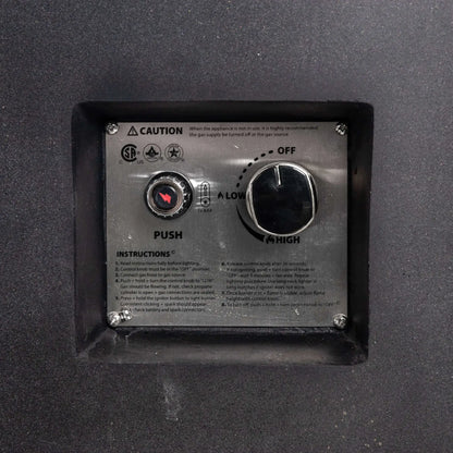 Close-up of the Flame Havens Refuge Series 43-inch Round Propane Gas GFRC Concrete Fire Pit recessed CSA-certified ignition control panel. The image showcases the electronic push-button igniter, flame adjustment control knob, operating instructions, and stainless steel control plate neatly integrated into the black GFRC concrete fire pit for convenient operation.