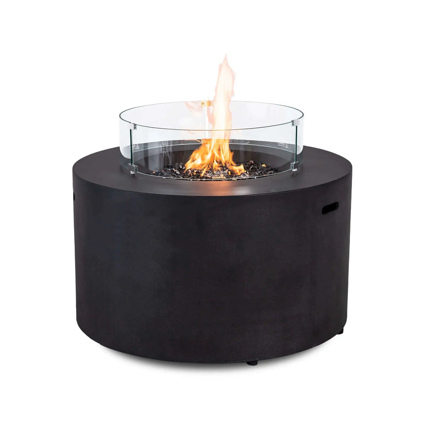 The Flame Havens Refuge Series 43-inch Round Propane Gas GFRC Concrete Fire Pit in Black featuring the optional tempered glass wind guard surrounding a vibrant propane flame over premium black reflective fire glass. The clear wind guard enhances flame stability while preserving unobstructed views of the fire and modern GFRC concrete fire pit design.