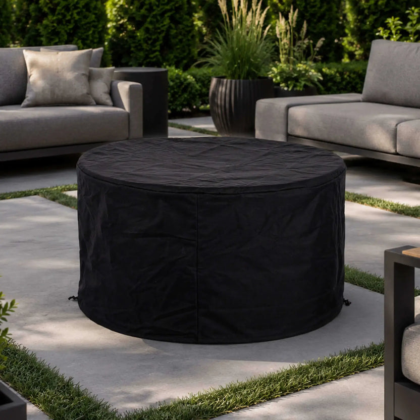 The Flame Havens Refuge Series 43-inch Round Propane Gas GFRC Concrete Fire Pit in Gray protected by the custom-fit black canvas fabric cover. The weather-resistant cover provides full protection from rain, dust, and debris while maintaining a clean appearance and extending the life of the premium GFRC outdoor fire pit.