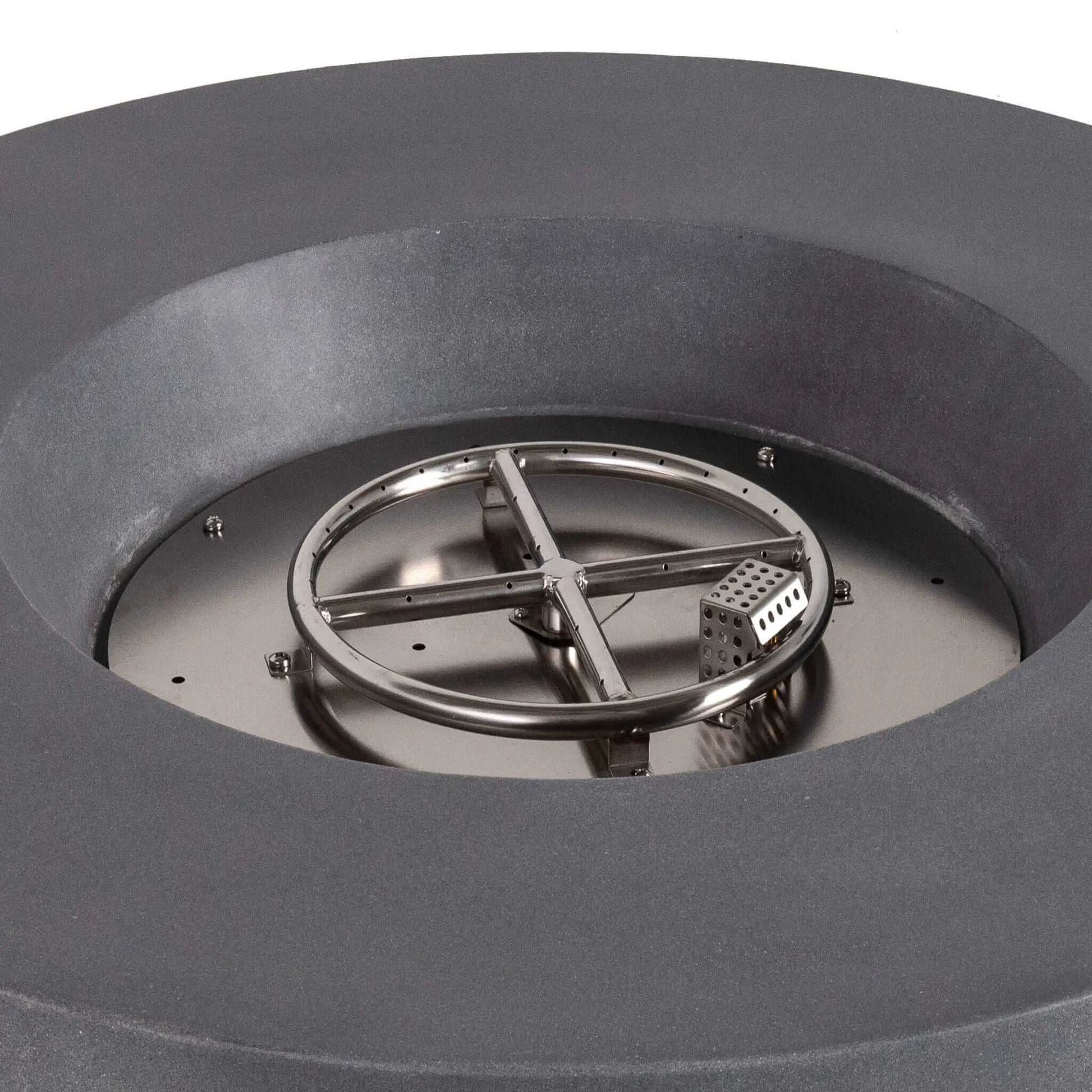 Close-up of the stainless steel circular burner and integrated CSA-certified ignition system inside the Flame Havens Refuge Series 43-inch Round Propane Gas GFRC Concrete Fire Pit in Gray. The image showcases the precision burner ring, ignition cage, and premium stainless steel components before black reflective fire glass is installed.