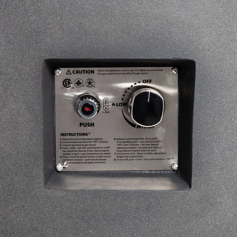 Close-up of the recessed CSA-certified ignition and control panel on the Flame Havens Refuge Series 43-inch Round Propane Gas GFRC Concrete Fire Pit in Gray. The stainless steel control plate features the electronic igniter, flame adjustment knob, operating instructions, and safety markings for reliable propane fire pit operation.
