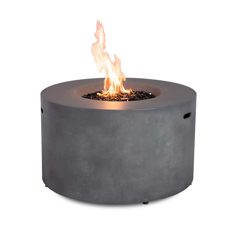 Rear perspective of the Flame Havens Refuge Series 43-inch Round Propane Gas GFRC Concrete Fire Pit in Gray operating with a bright propane flame rising through premium black reflective fire glass. The clean exterior showcases the smooth GFRC concrete construction while emphasizing the natural flame and contemporary circular design.