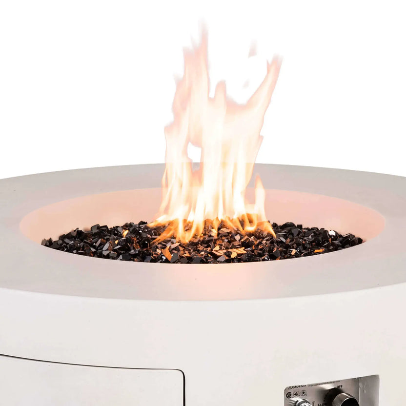 The Flame Havens Refuge Series 43-inch Round Propane Gas GFRC Concrete Fire Pit in White with tempered black reflective fire glass producing a vibrant natural flame. This close-up showcases the illuminated fire media, contemporary GFRC concrete finish, and clean burner design, creating an elegant focal point for luxury outdoor living spaces.