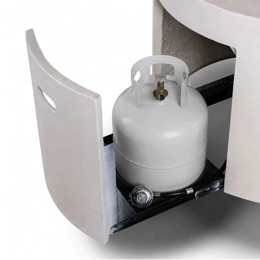The Flame Havens Refuge Series 43-inch Round Propane Gas GFRC Concrete Fire Pit in White with the hidden propane drawer fully extended and a standard 20-pound propane tank installed. The image demonstrates the concealed tank storage system, integrated regulator, and convenient slide-out access for quick propane replacement.