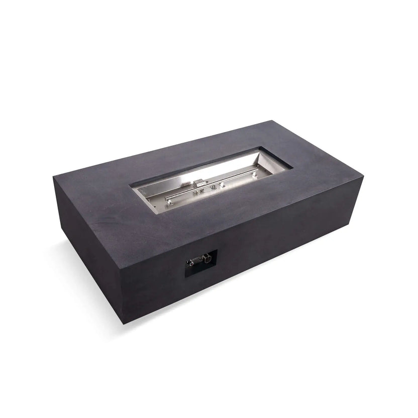 Close-up angled view of the Flame Havens Refuge Series black rectangle natural gas GFRC fire pit with the stainless steel burner tray exposed, highlighting the linear burner, CSA ignition cage, polished metal hardware, and recessed firebox before fire glass is added.