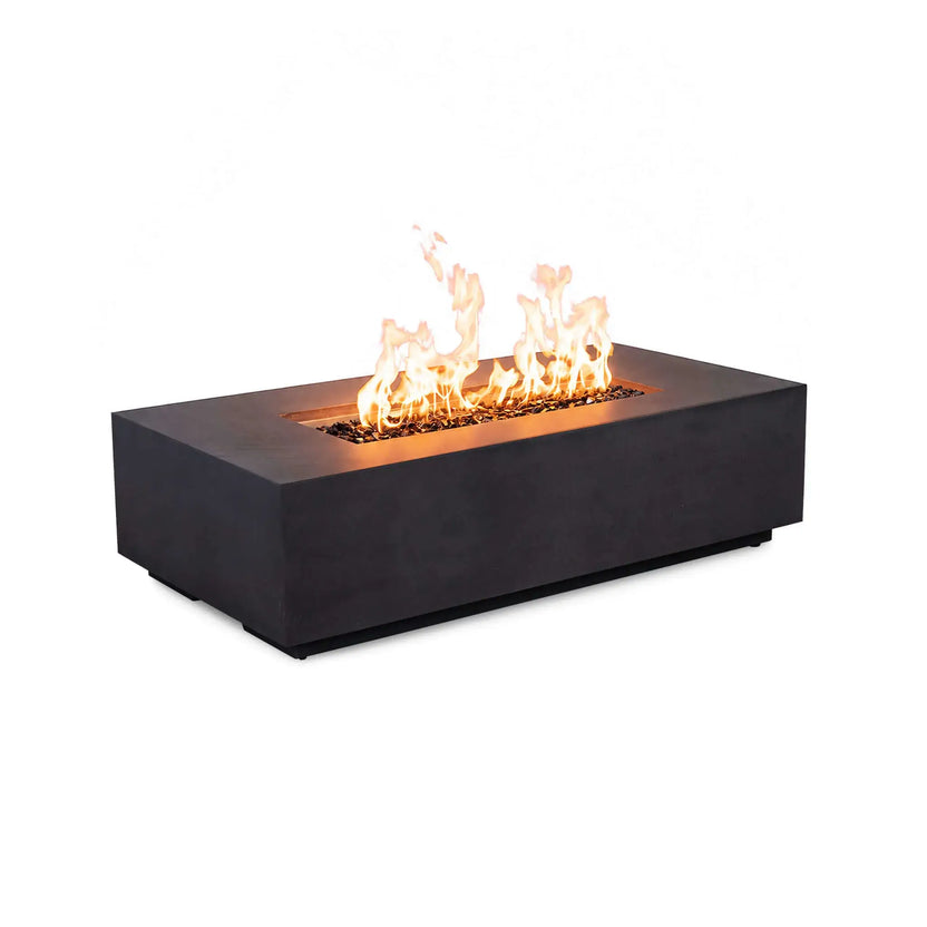 Flame Havens Refuge Series 56 x 30 x 15 inch rectangle black GFRC natural gas fire pit shown burning with bright flames over tempered black fire glass, photographed at an angle on a white background with the control panel not visible.