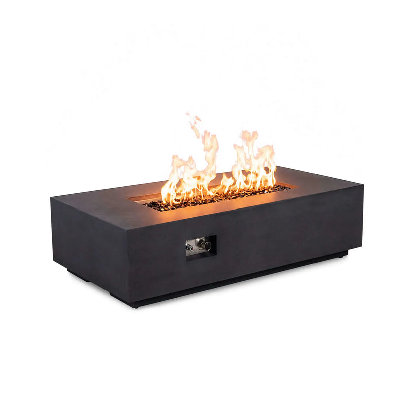 Angled view of the Flame Havens Refuge Series 56 x 30 x 15 inch rectangle black natural gas GFRC fire pit with flames rising from tempered black fire glass, showing the front control panel and modern low-profile concrete design on a white background.