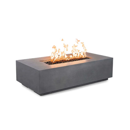 Angled front view of the Flame Havens Refuge Series 56 x 30 x 15 inch rectangle natural gas gray GFRC fire pit burning with bright flames over reflective tempered black fire glass. The streamlined design features concealed controls, creating a clean, contemporary appearance.