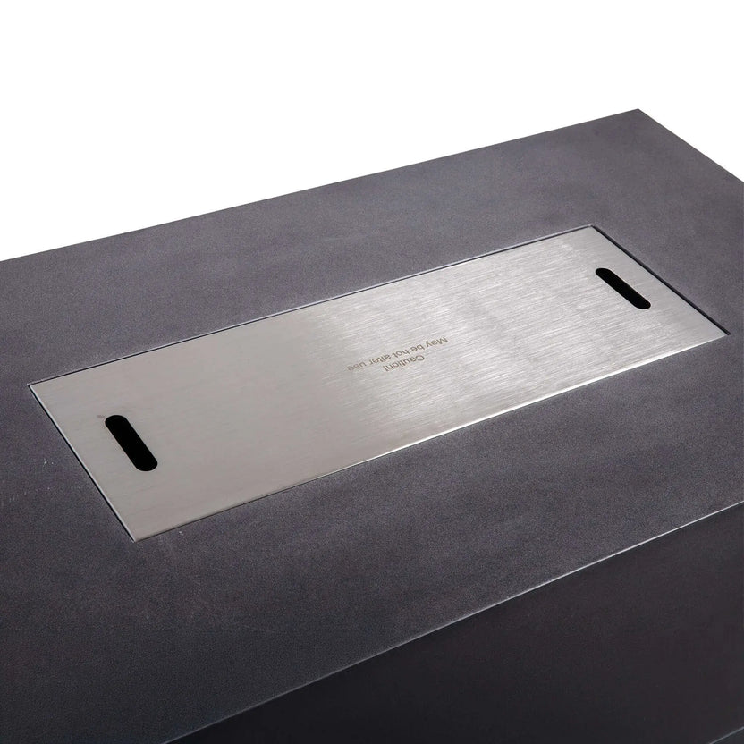 Close-up of the Flame Havens Refuge Series 56 x 30 x 15 inch rectangle natural gas GFRC concrete fire pit featuring the flush-mounted brushed stainless steel burner cover with integrated lifting slots, creating a sleek tabletop surface against the black concrete finish.