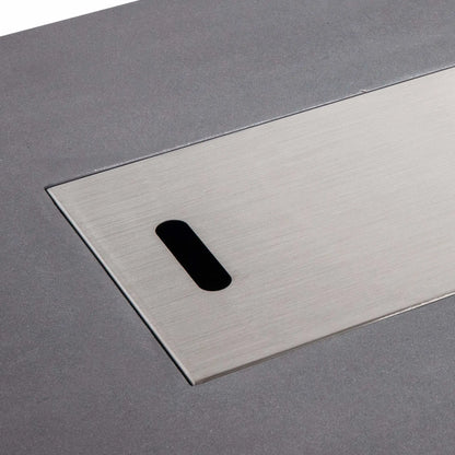 Close-up of the Flame Havens Refuge Series 56 x 30 x 15 inch rectangle natural gas gray GFRC fire pit with the brushed stainless steel burner cover installed. The precision-fit cover sits flush within the burner opening, providing a clean tabletop appearance when the fire feature is not in use.