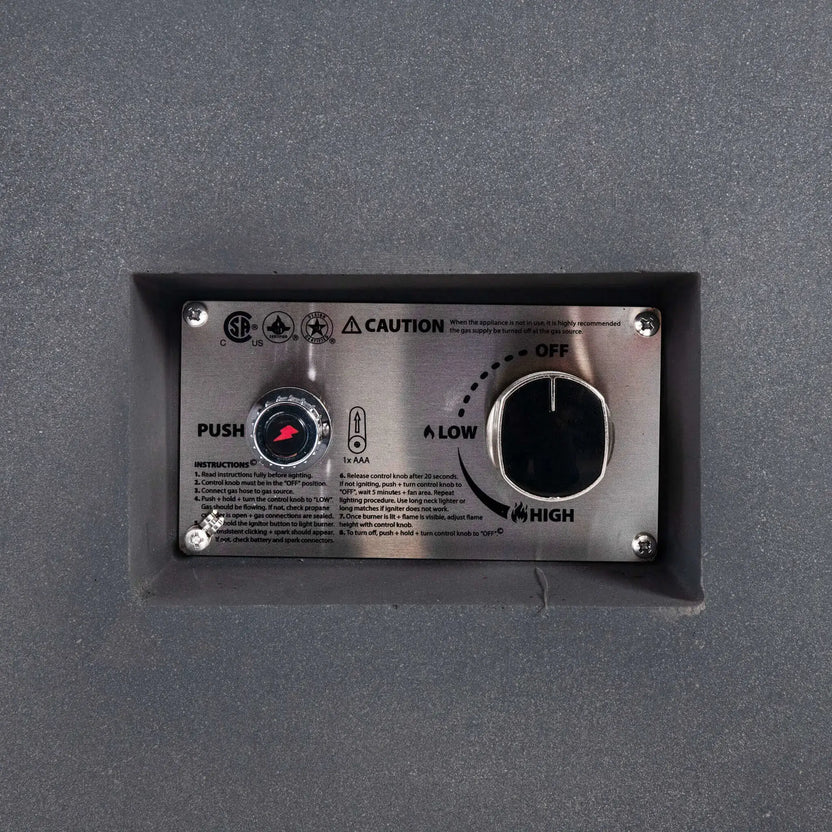 Close-up of the Flame Havens Refuge Series 56 x 30 x 15 inch rectangle natural gas gray GFRC fire pit recessed control panel, featuring the CSA-certified ignition button, flame adjustment knob, lighting instructions, and stainless steel faceplate for reliable and convenient operation.
